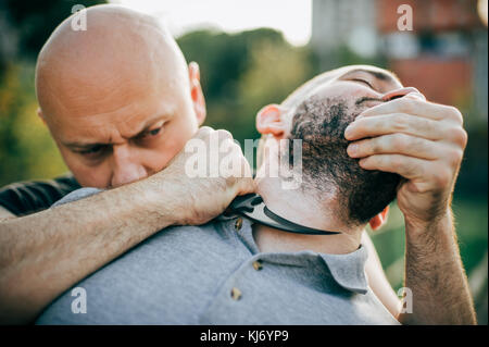 Knife threat. Kapap instructor demonstrates martial arts self defense knife threat disarming technique. Weapon retention and disarm training. Demonstr Stock Photo