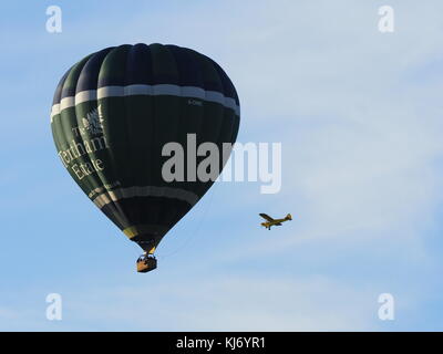 A near miss with a majestic hot air balloon glides over Stratford Upon Avon, England UK in crowded skies Stock Photo