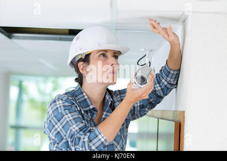 pretty female installing cctv camera Stock Photo