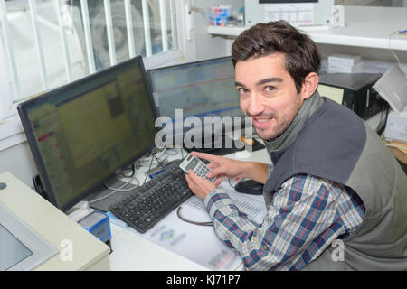 Man using calculator in work office Stock Photo