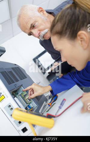 engineer training female apprentice on cnc machine Stock Photo