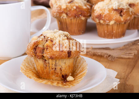 Muffin on a white plate with cup of coffee in background Stock Photo