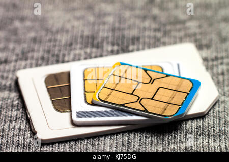 Set of mini, micro and nano simcard. Isolated on grey cloth texture background Stock Photo