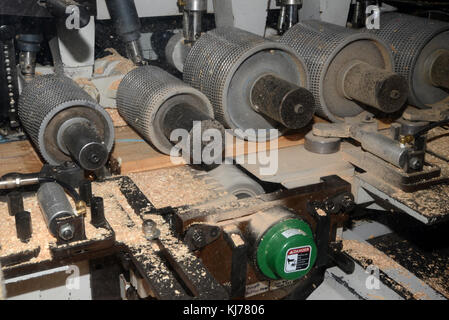 detail of the cutters inside a four sider machine, used to plane rough edges from four sides of large pine planks in a wood processing factory near Gr Stock Photo