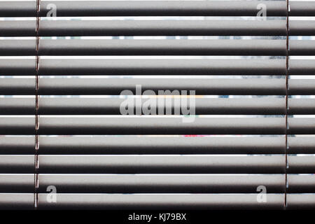 Fragment of the white Venetian blinds with lift cord and turning rod of a manual control on a foreground Stock Photo
