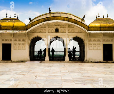 Indian family admires Taj Mahal from the golden pavilions of Agra Fort Stock Photo