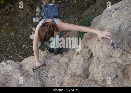Teenage girl climbing on rock, Dead Sea Region, Israel Stock Photo