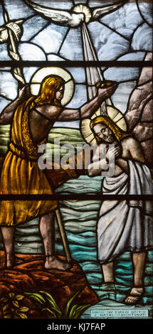 Stained glass depicting the baptism of Jesus Christ by John the Baptist. San Vittore Martire Church (Church of Saint Victor Maurus or the Moor the mar Stock Photo