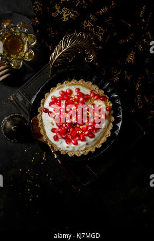 Yogurt Honey Tart covered in fresh pomegranate seeds Stock Photo