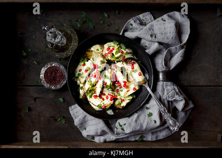 Eggplant in sauce, covered in pomegranate seeds Stock Photo