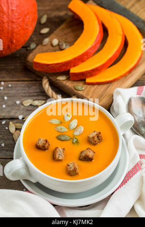 Pumpkin soup puree with seeds and wooden background. Stock Photo