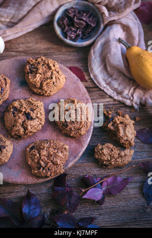 Pumpkin chocolate chip cookies served on a ceramic plate on rustic wooden table Stock Photo