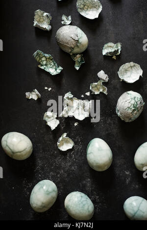 Boiled eggs dyed in a dark blue coloring with beautiful cracked shells on surface. Stock Photo