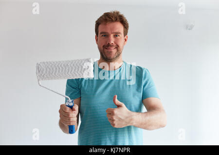 Smiling man holding a roller in front of him Stock Photo