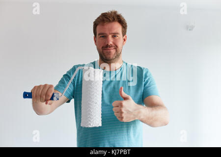 Smiling man holding a roller in front of him Stock Photo