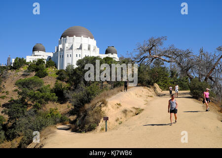 Visitors walking along the trail on path and view of Griffith Observatory building in Griffith Park LA Los Angeles, California US  KATHY DEWITT Stock Photo