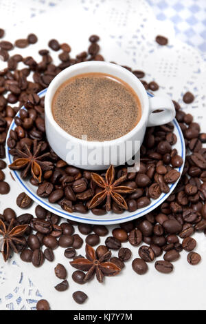 Composition of a coffee cup with spreaded beans and star anise. Stock Photo