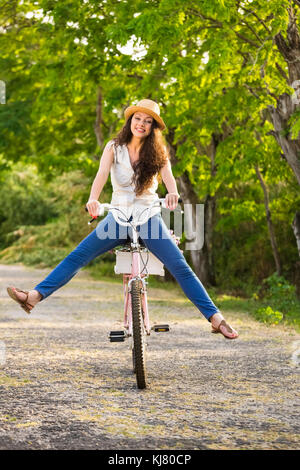 A beautiful and happy young woman riding her bicycle Stock Photo