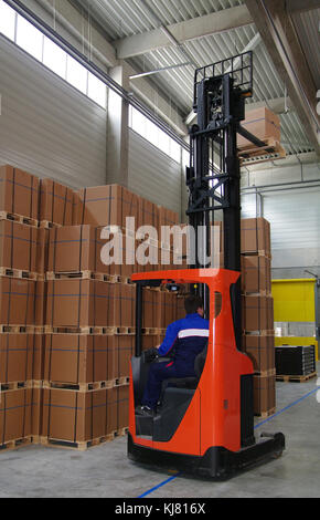 Arrange warehouse with a forklift. Forklift moving pallets in warehouse Stock Photo