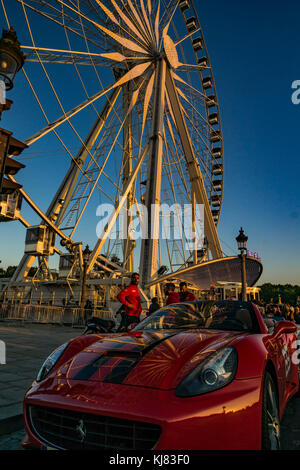 Paris, France. A Ferrari sports car near a Ferris Wheel at the Place de la Concorde, near the Luxor obelisk and the Jardin des Tuileries. Stock Photo