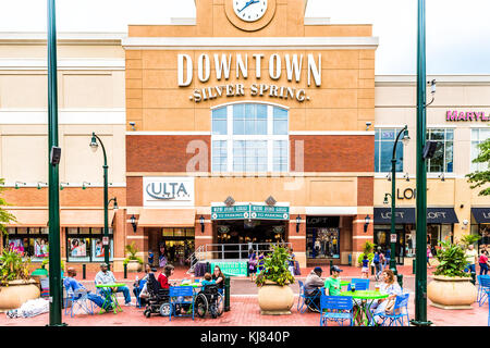 Silver Spring, USA - September 16, 2017: Downtown area of city in Maryland with large sign on shopping mall building and clock with people sitting, ea Stock Photo