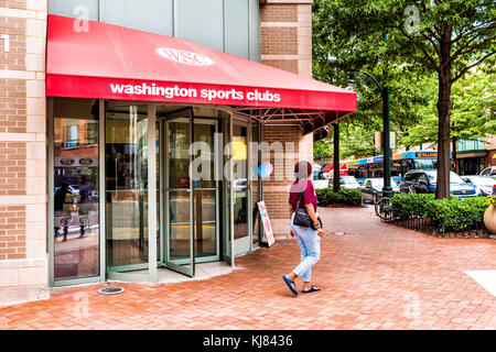 Silver Spring, USA - September 16, 2017: Woman walking by Washington Sports Clubs gym entrance in downtown area of city in Maryland with sign on stree Stock Photo