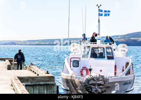 Perce, Canada - June 6, 2017: Bonaventure Island Park entrance in Gaspe Peninsula, Quebec, Gaspesie region with boat ferry on dock pier, people Stock Photo