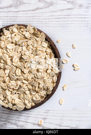 Oat flakes in wooden bowl from above Stock Photo