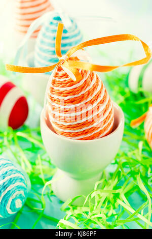 Selective focus on front orange Easter egg in the cup Stock Photo