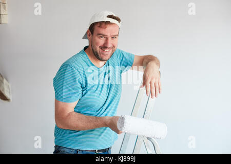 Smiling man holding a roller in front of him Stock Photo