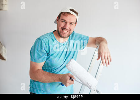 Smiling man holding a roller in front of him Stock Photo