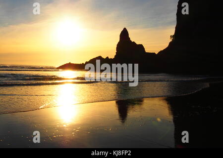 sunset at piha beach, new zealand Stock Photo