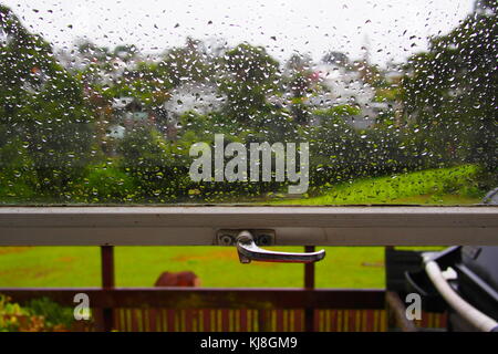 raindrops on window with garden in the background Stock Photo