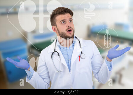 Surprised male doctor posing in a white uniform with medical illustrations. Stock Photo
