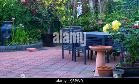 Beautiful springtime Mediterranean style courtyard garden with outdoor setting. Stock Photo