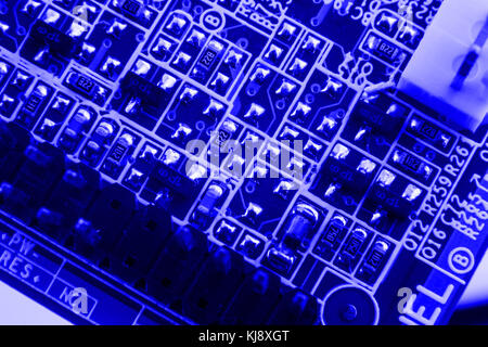Electronics components on modern PC computer motherboard blue background close macro isolate. Stock Photo