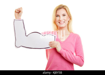 Young blonde woman holds cardboard muscles in front of her arm as a sign of strength and fitness Stock Photo