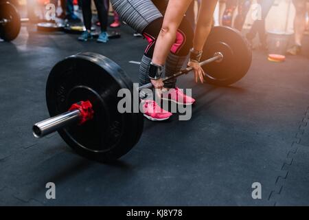 Woman preparing to barbell deadlift in functional fitness gym. Stock Photo