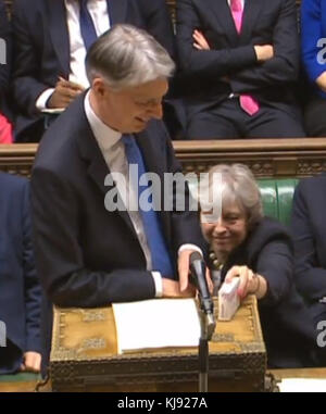 Chancellor Philip Hammond is given some cough sweets by Prime Minister Theresa May as he delivers his Budget in the House of Commons, London. Stock Photo