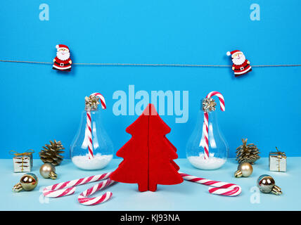 Christmas composition with Santa, decorative christmas tree, gifts and candy canes. Stock Photo