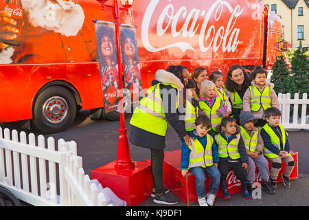 Bournemouth, Dorset, UK. 23rd Nov, 2017. The Christmas Coca Cola truck arrives at the Triangle in Bournemouth, as part of its Holidays are Coming Christmas campaign festive tour visiting locations around the country. Young children wearing hi viz vests have a group photo take in front of the truck Credit: Carolyn Jenkins/Alamy Live News Stock Photo