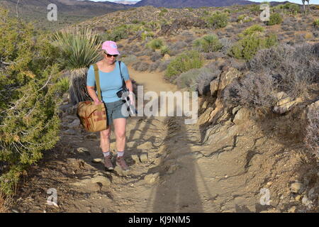 A women photographer walking up a mountain path. Stock Photo