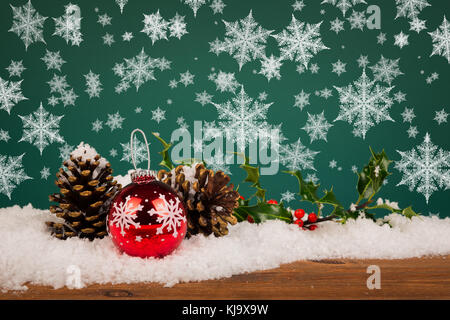 Christmas bauble still life with pine cones holly and snowflakes. Stock Photo