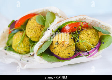 Baked falafel and fresh vegetables in pita bread, light background. Stock Photo