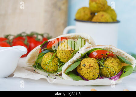 Baked falafel and fresh vegetables in pita bread, light background. Stock Photo