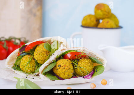 Baked falafel and fresh vegetables in pita bread, light background. Stock Photo