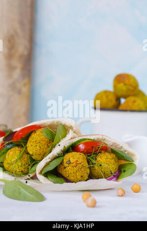 Baked falafel and fresh vegetables in pita bread, light background. Stock Photo