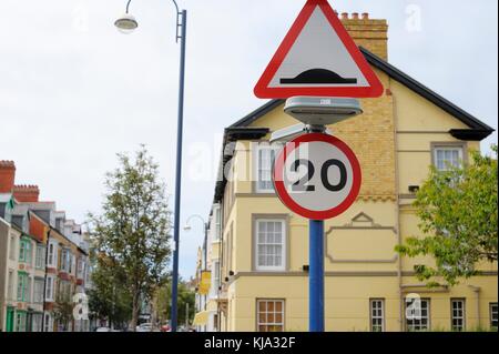 20 miles per hour speed restriction sign with speed hump warning sign, Wales, UK Stock Photo