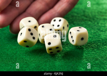 Hand throwing dices on green felt Stock Photo