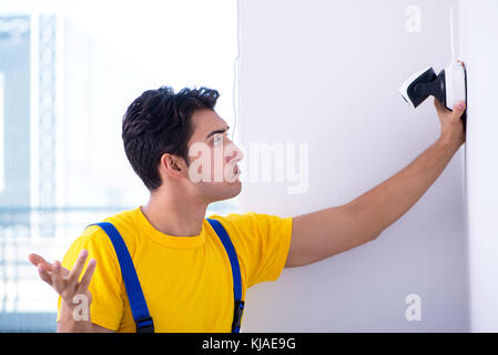 Contractor installing surveillance CCTV cameras in office Stock Photo